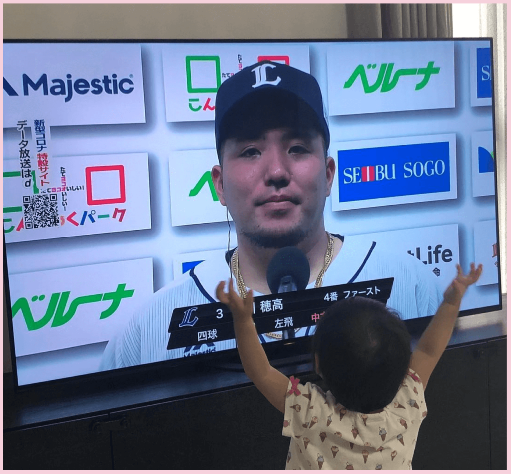 テレビに映る山川穂高選手を見て手をあげる子供（真央ちゃん）の画像